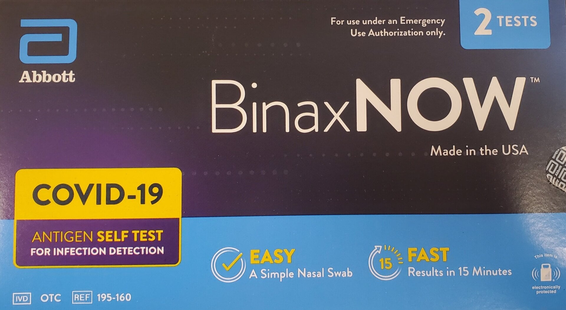 Front of a BinaxNOW COVID-19 antigen self-test kit box showing product branding, instructions for emergency use, two tests included, and features like easy nasal swab and 15-minute fast results.